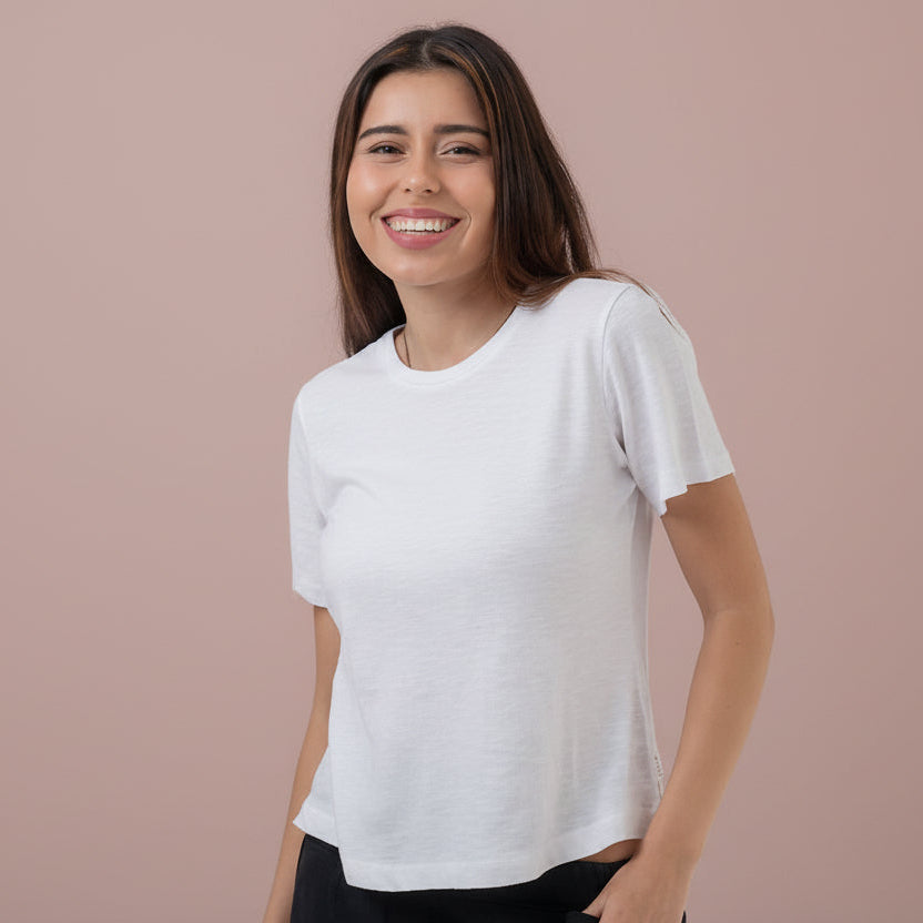 Woman wearing a white t-shirt and black pants on a white background