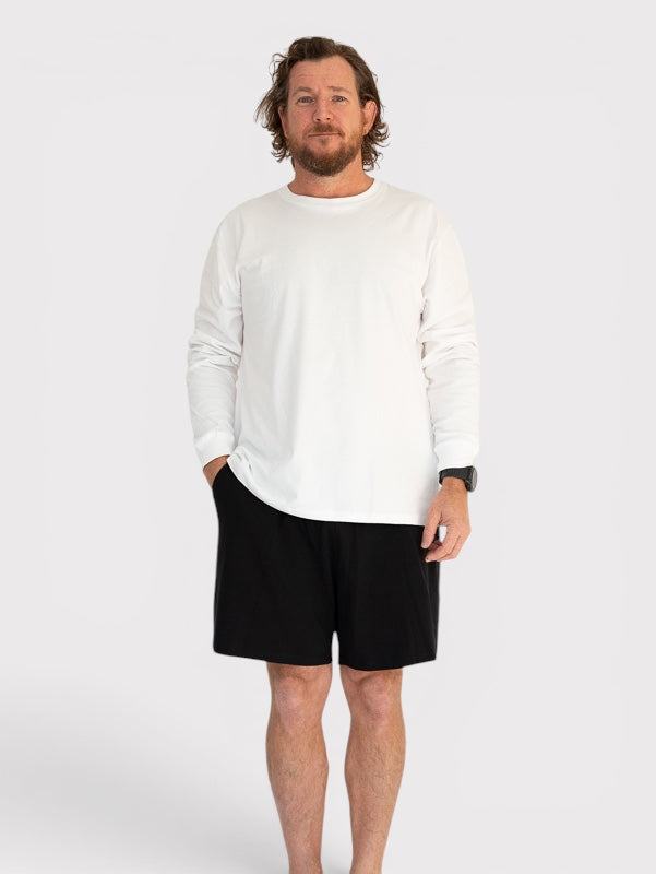 Man wearing a white sweater and black shorts on a white background