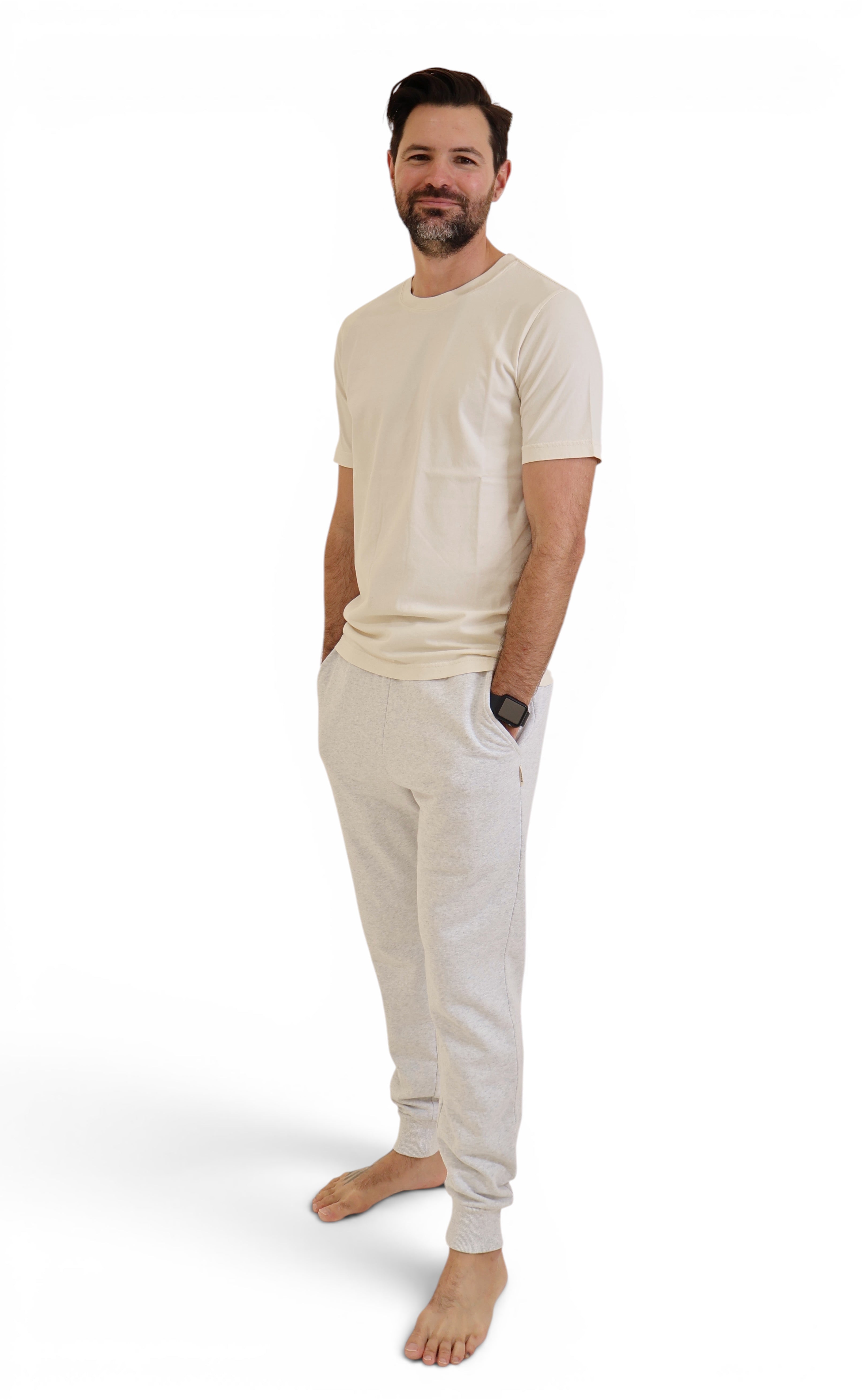 Natural raw organic cotton t-shirt and grey trackpants on man.
