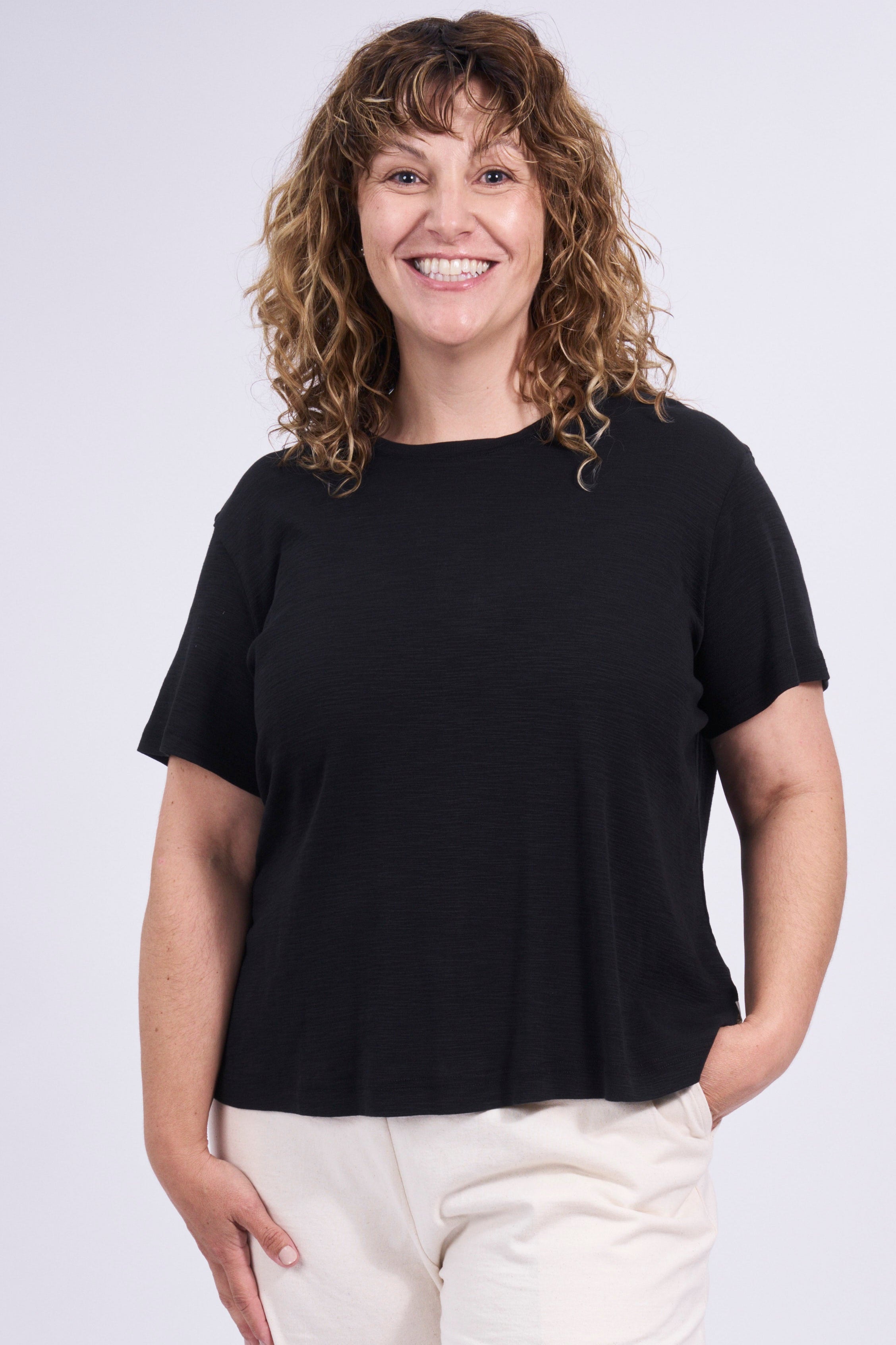 Woman wearing a black t-shirt and white shorts on a white background