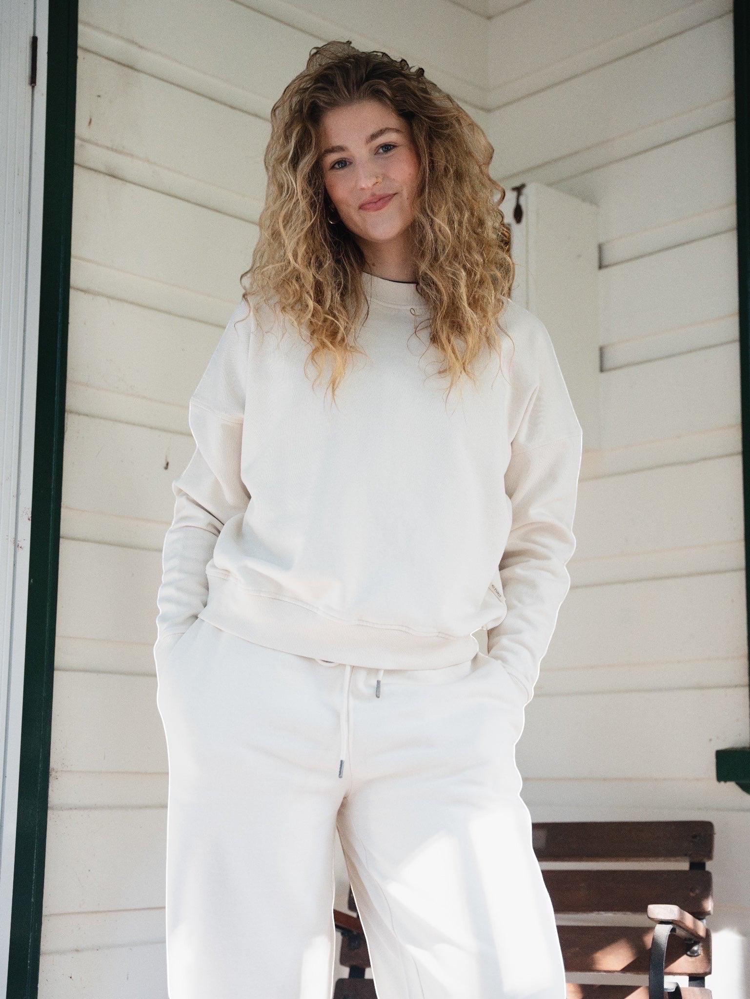 Woman wearing a STAPLE Co boxy cream crewneck pullover made from Regenerative Organic Certified cotton fleece.