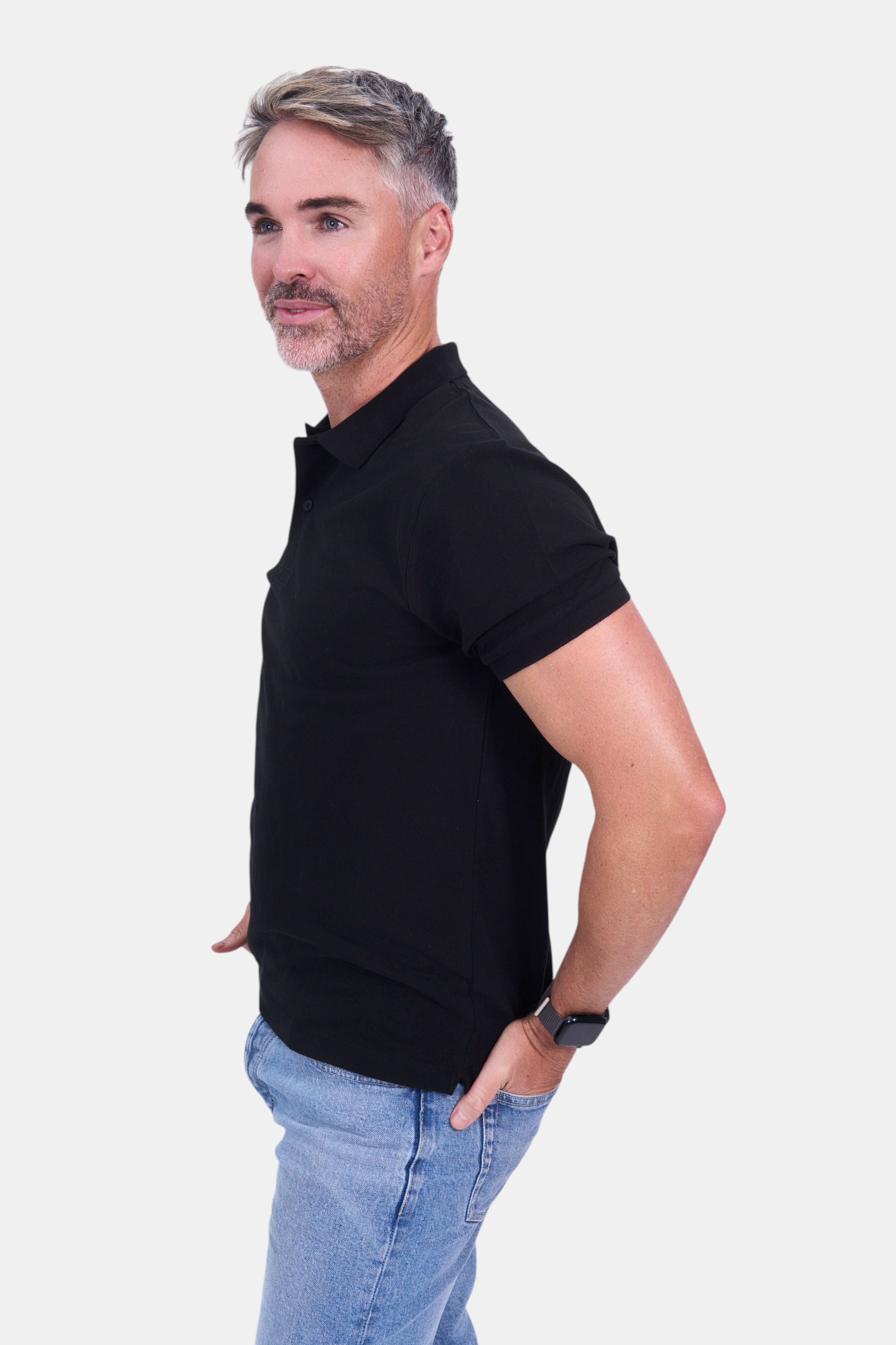STAPLE Co black organic cotton short-sleeve polo shirt on a man wearing blue jeans.