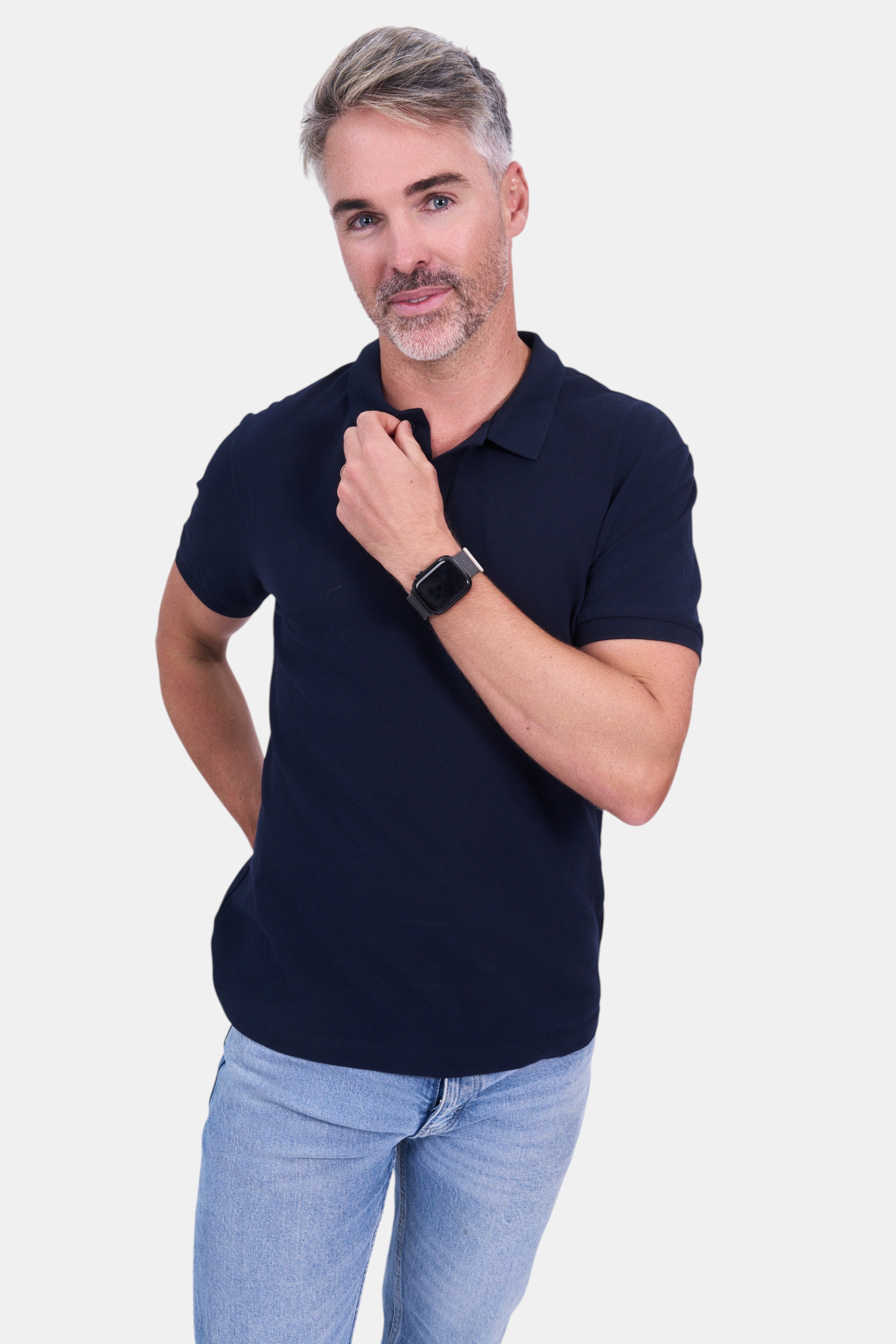 STAPLE Co navy blue organic cotton short-sleeve polo shirt worn by a man with light wash jeans.