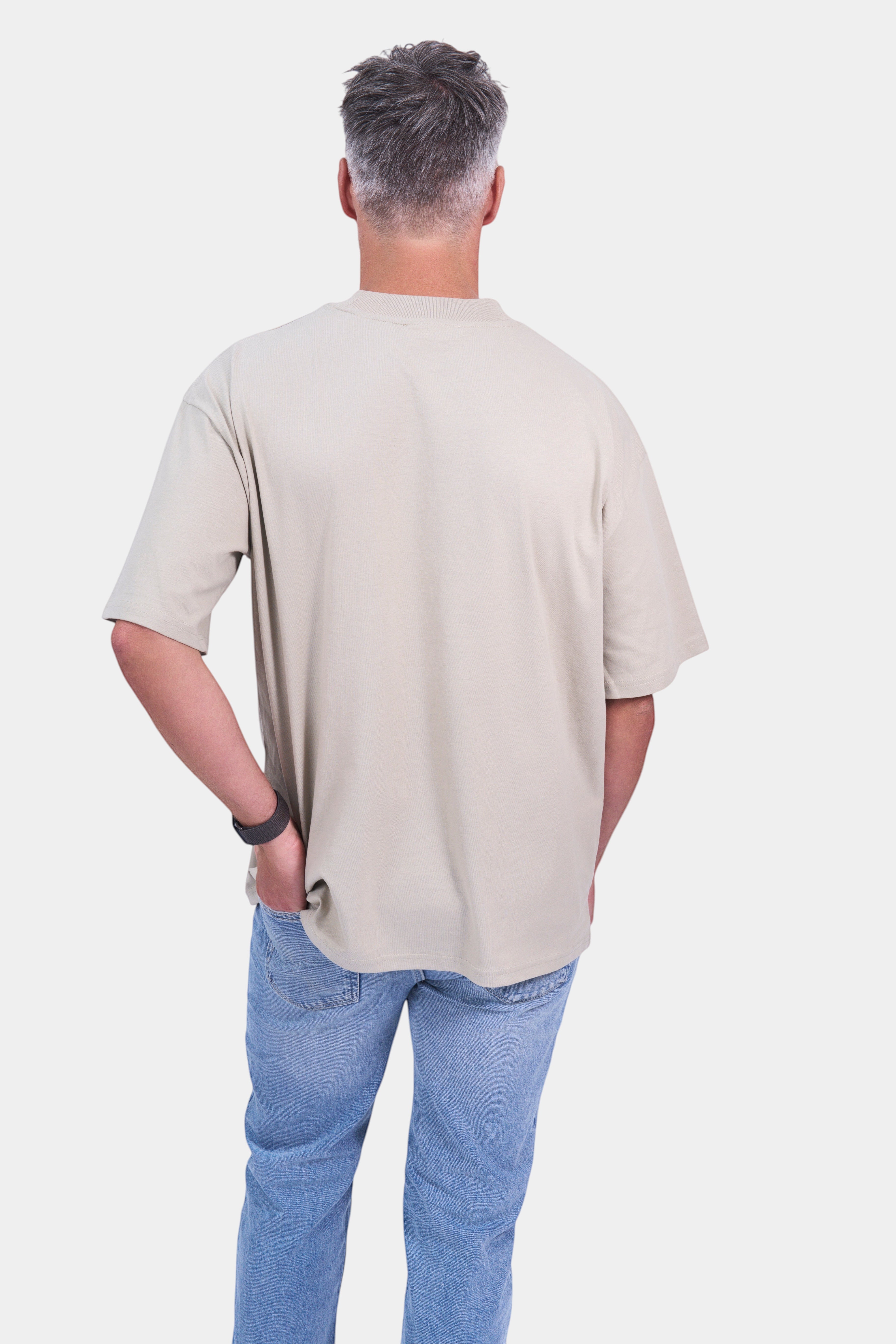 STAPLE Co organic cotton oversized high neck t-shirt on a man wearing blue jeans.