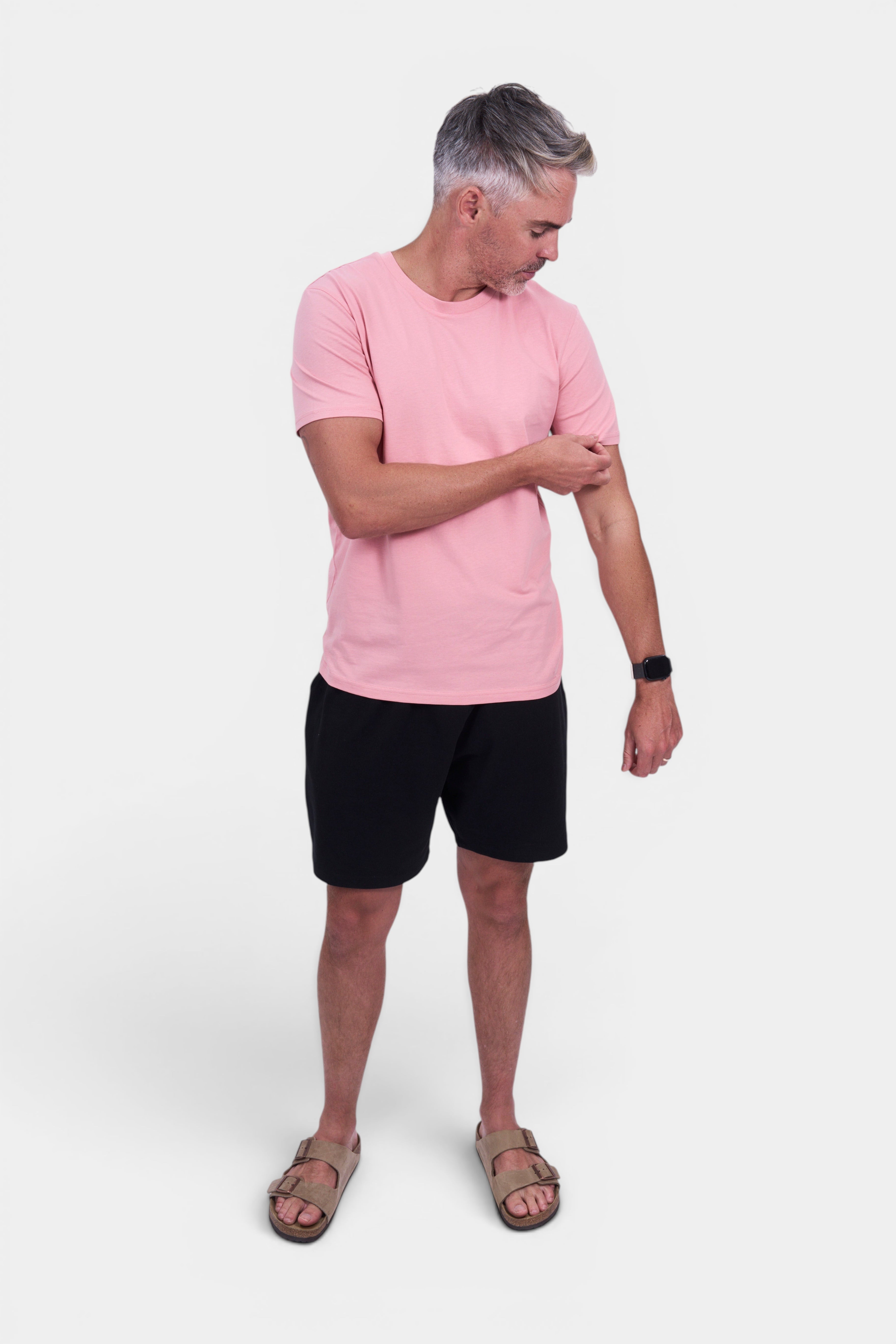 STAPLE Co. classic fit organic cotton t-shirt in light pink, worn by a man with black shorts and sandals.