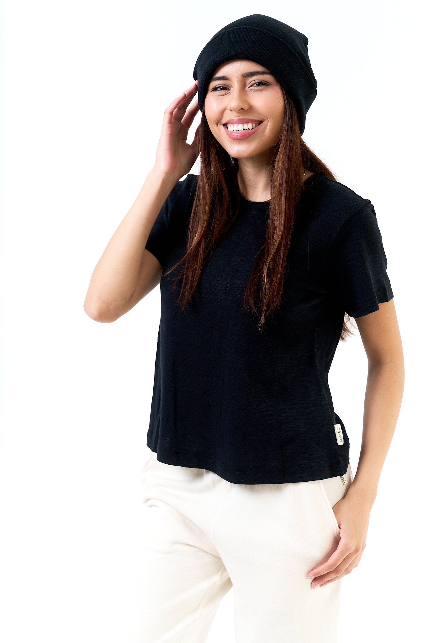 Person wearing a black t-shirt and black beanie on a white background