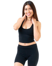 Woman wearing a black sports bra and shorts on a white background