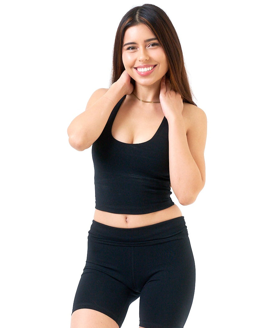 Woman wearing a black sports bra and shorts on a white background