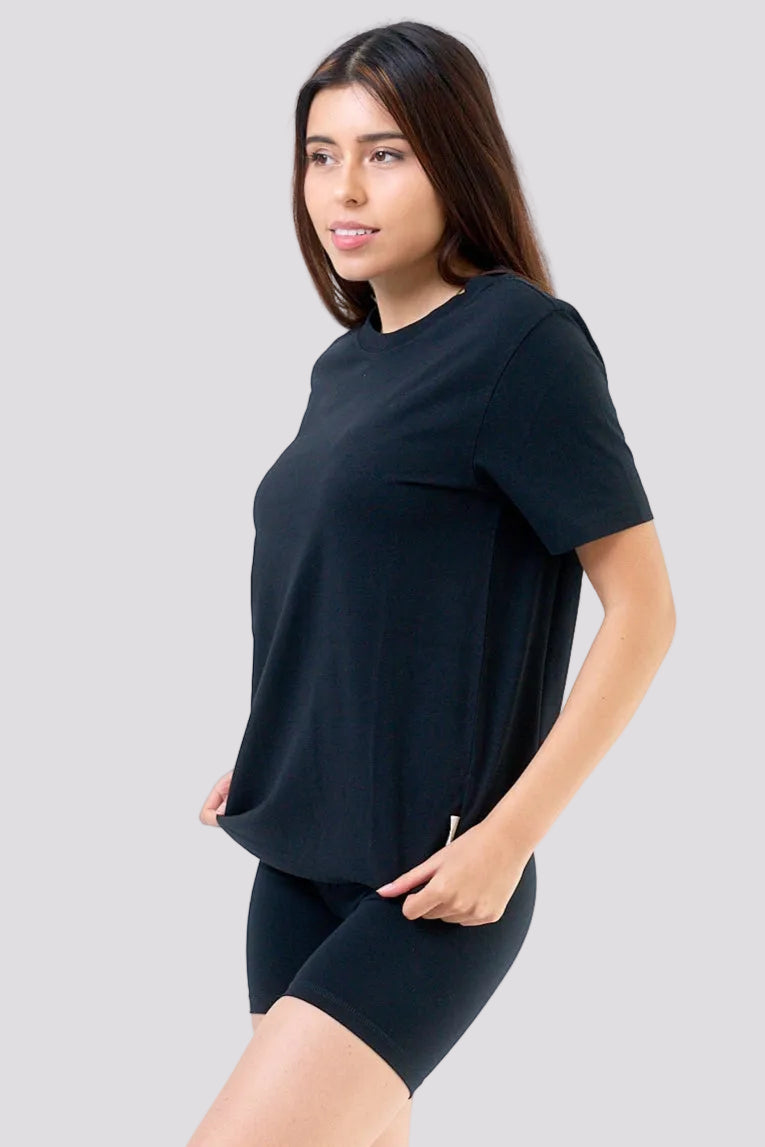 Woman wearing a black t-shirt and black shorts on a white background