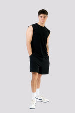Man wearing a black sleeveless shirt and shorts on a white background