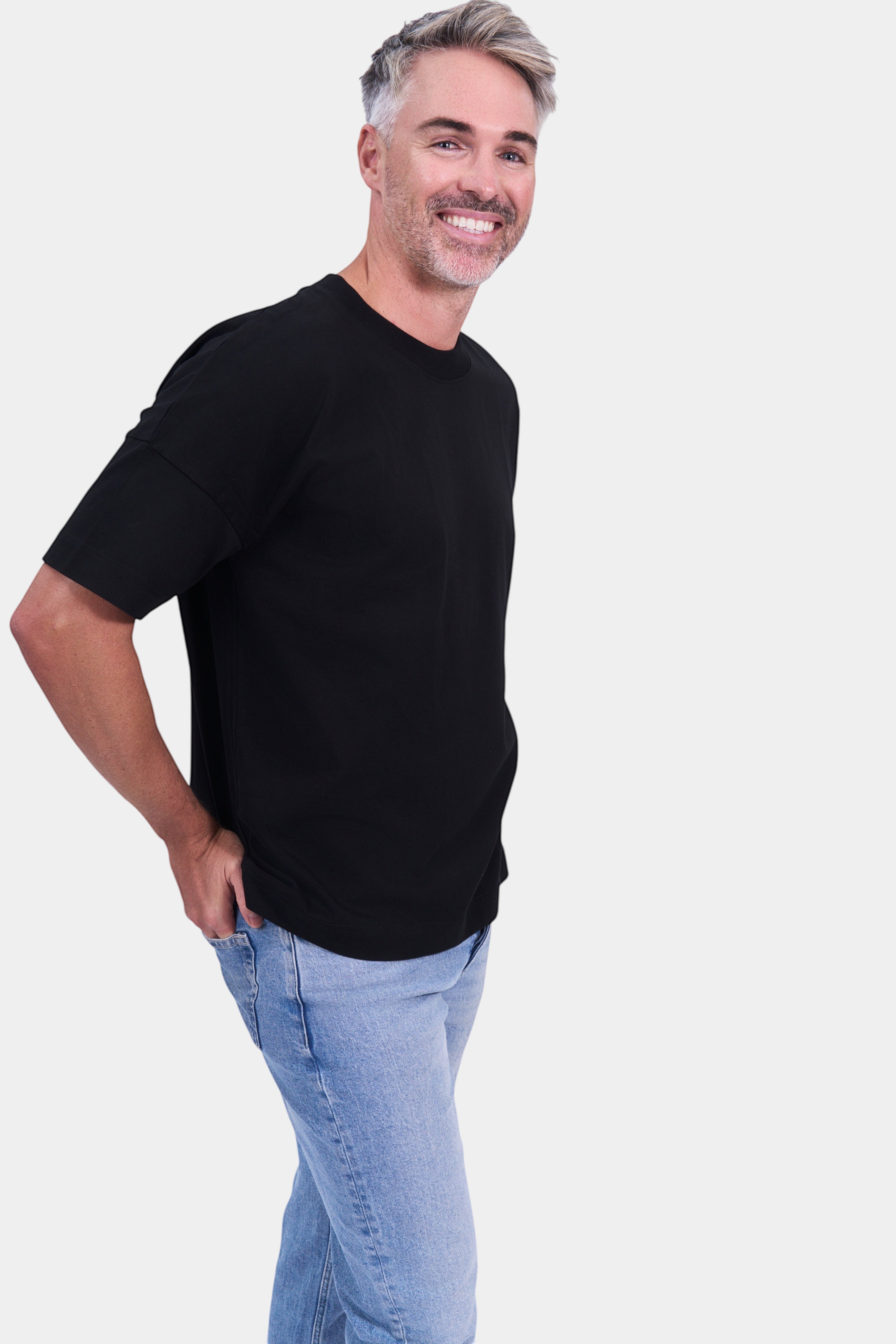 STAPLE Co black organic cotton high neck oversized t-shirt on a man with light wash jeans.