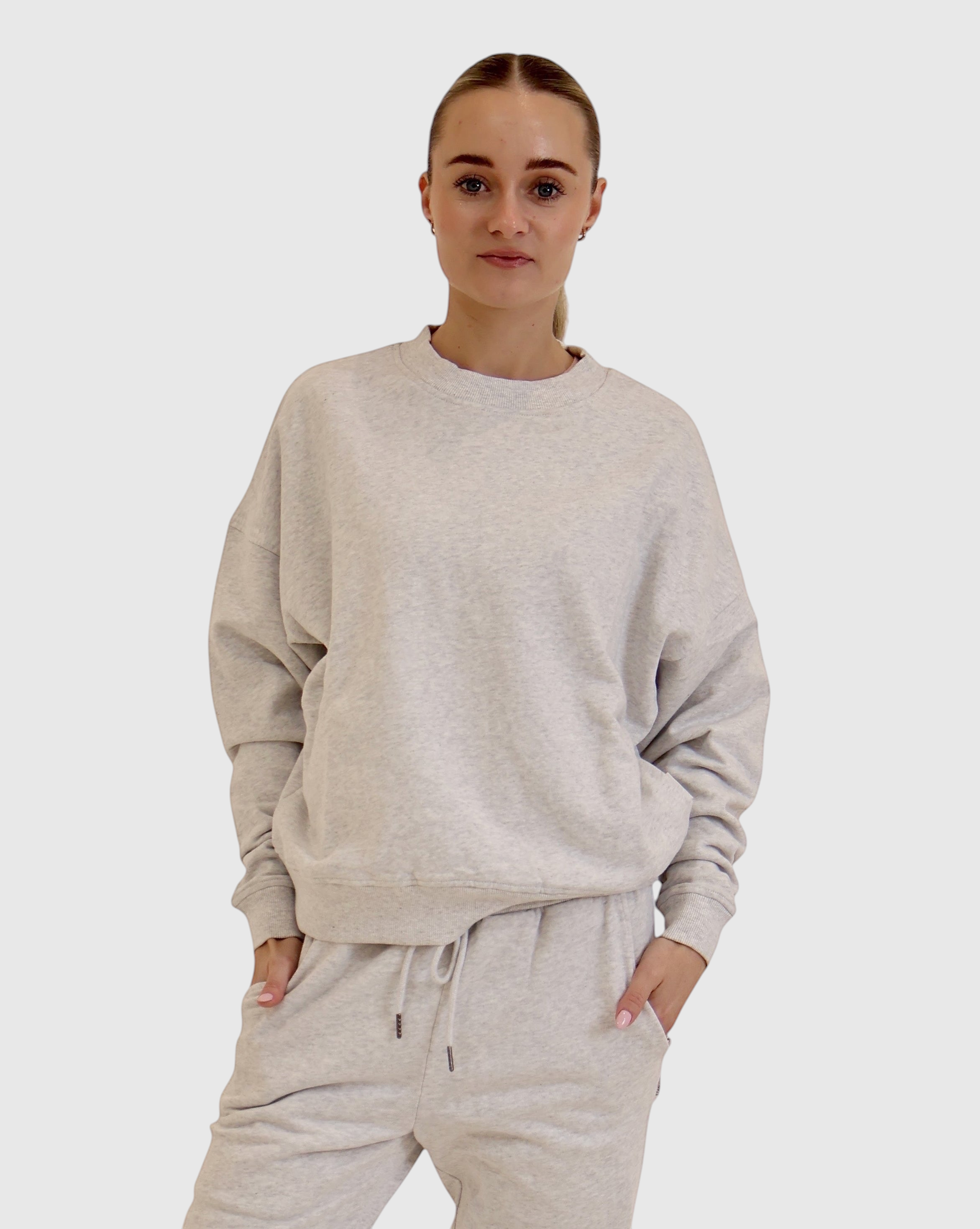 Model wearing a STAPLE Co boxy crewneck pullover in light grey organic cotton fleece against a white background.
