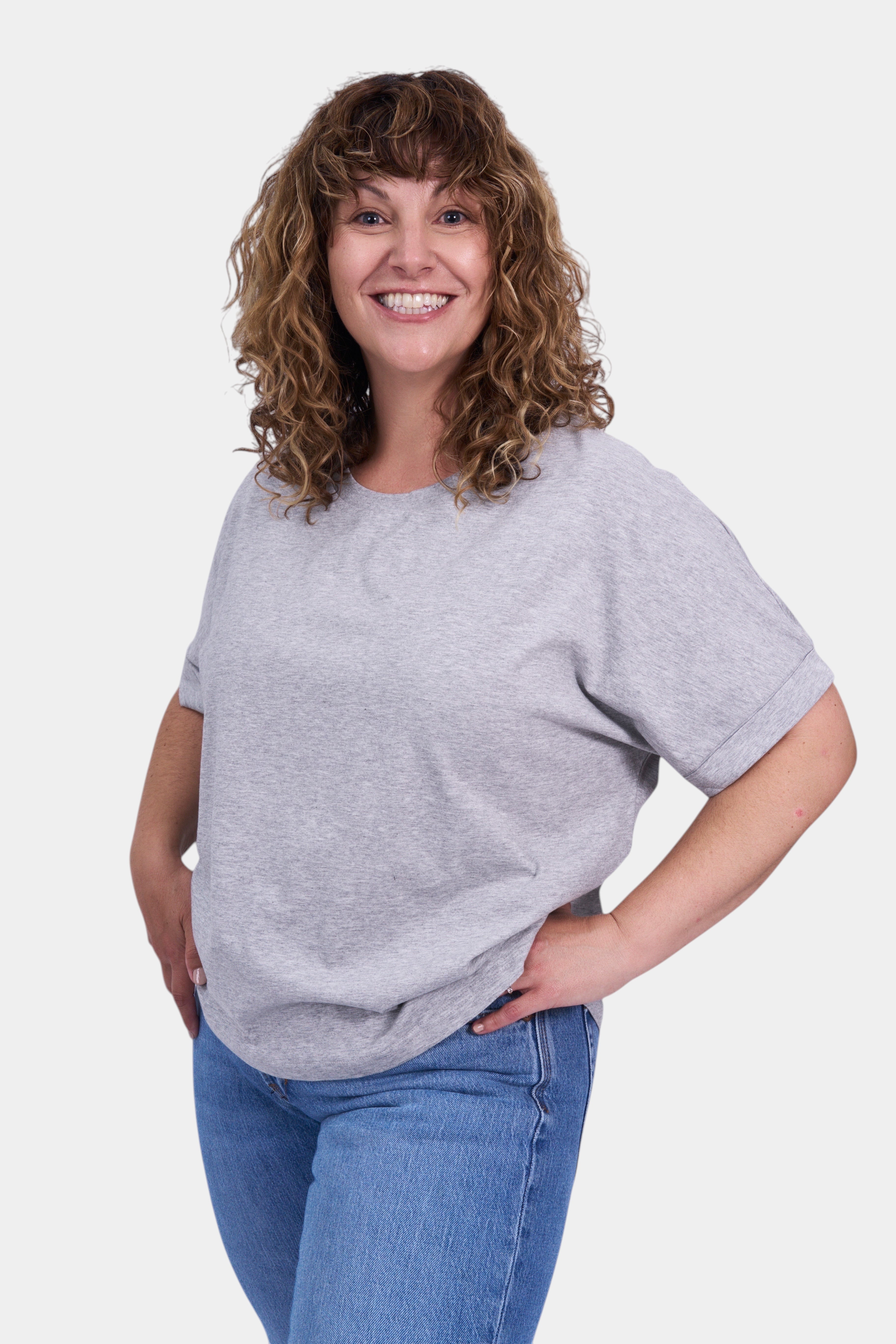 STAPLE Co grey organic cotton boxy t-shirt with rolled sleeves on a smiling woman.