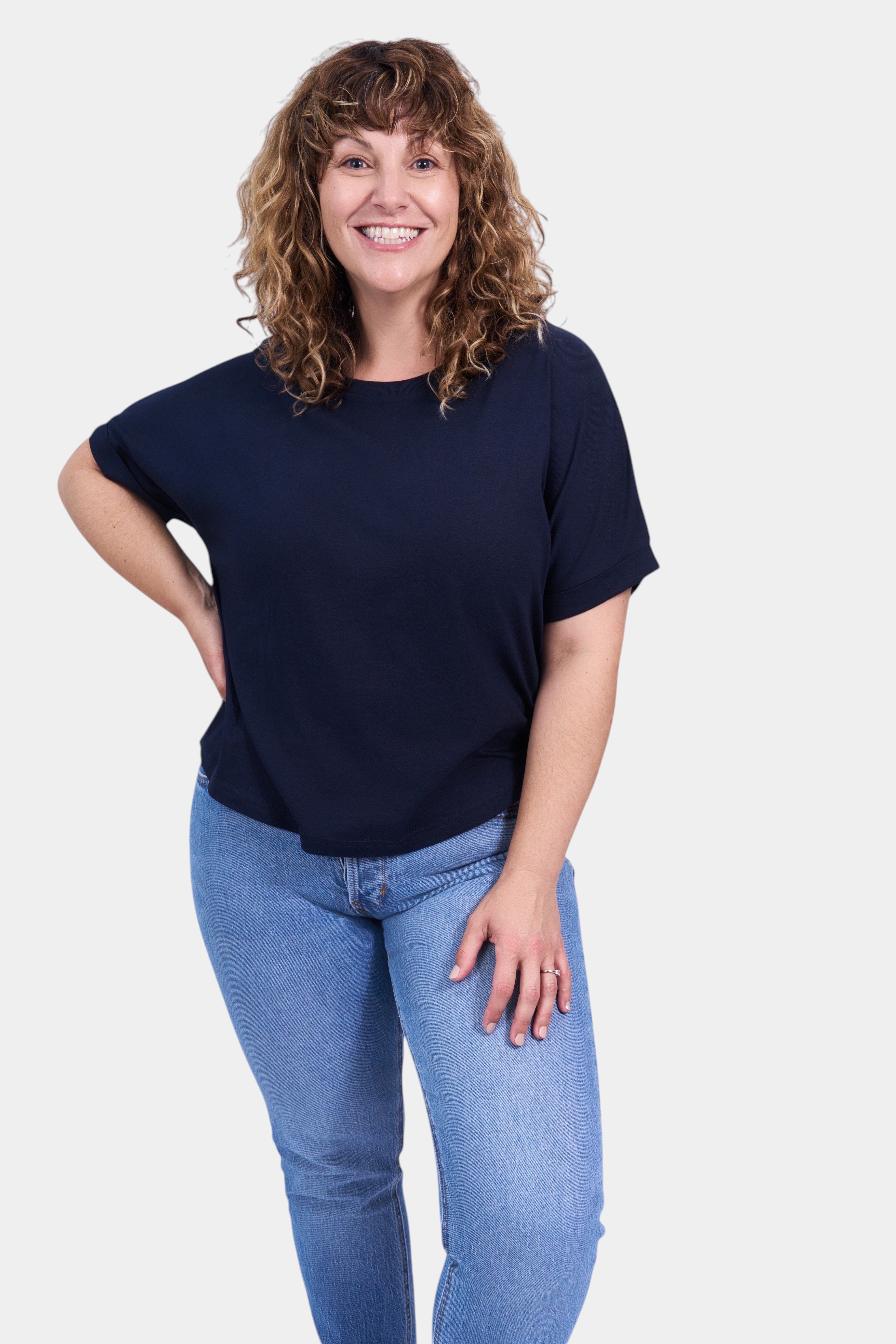 STAPLE Co navy blue organic cotton boxy t-shirt with rolled sleeves on a woman.