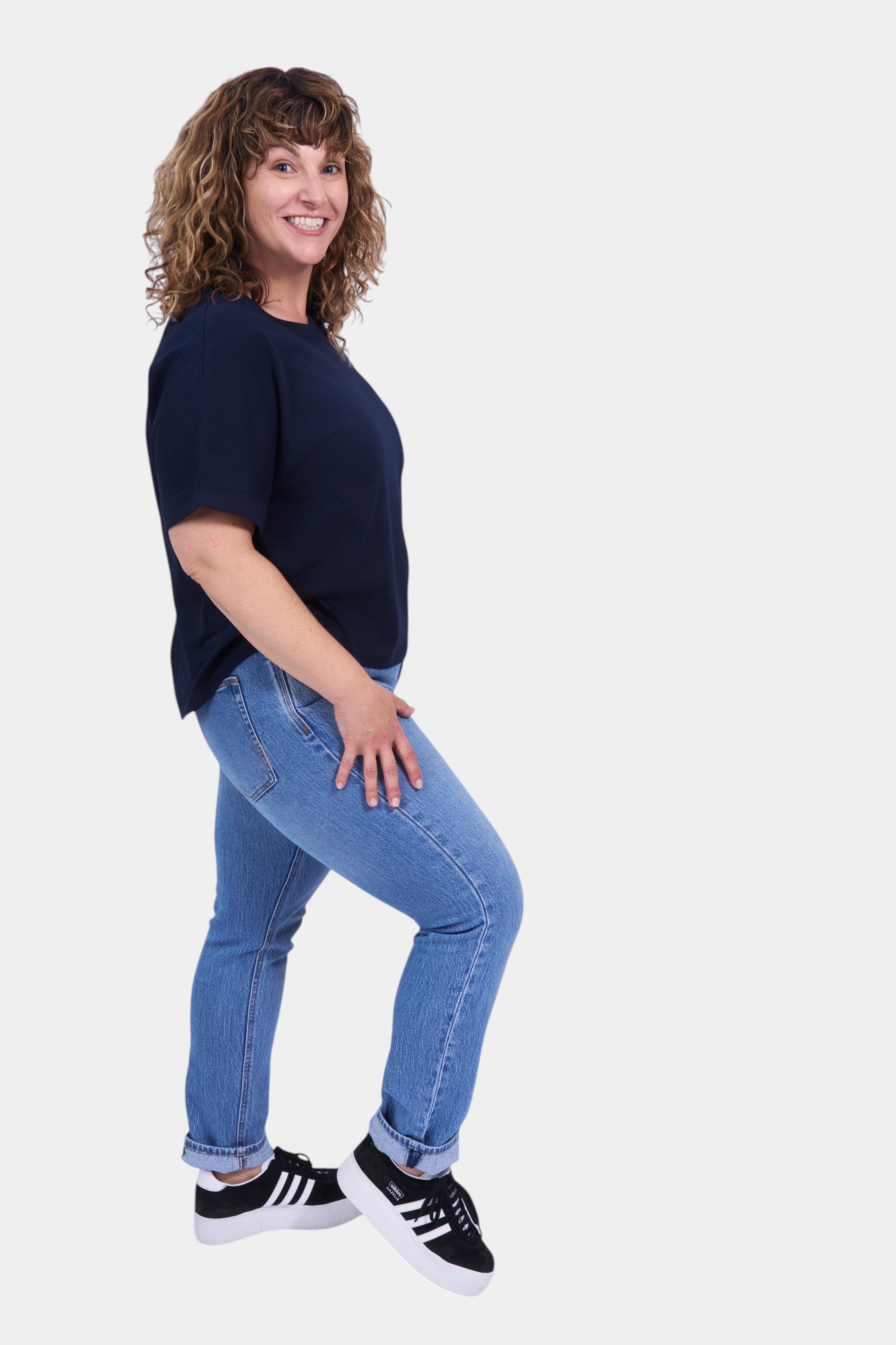 STAPLE Co navy blue organic cotton boxy t-shirt with rolled sleeves on a woman.