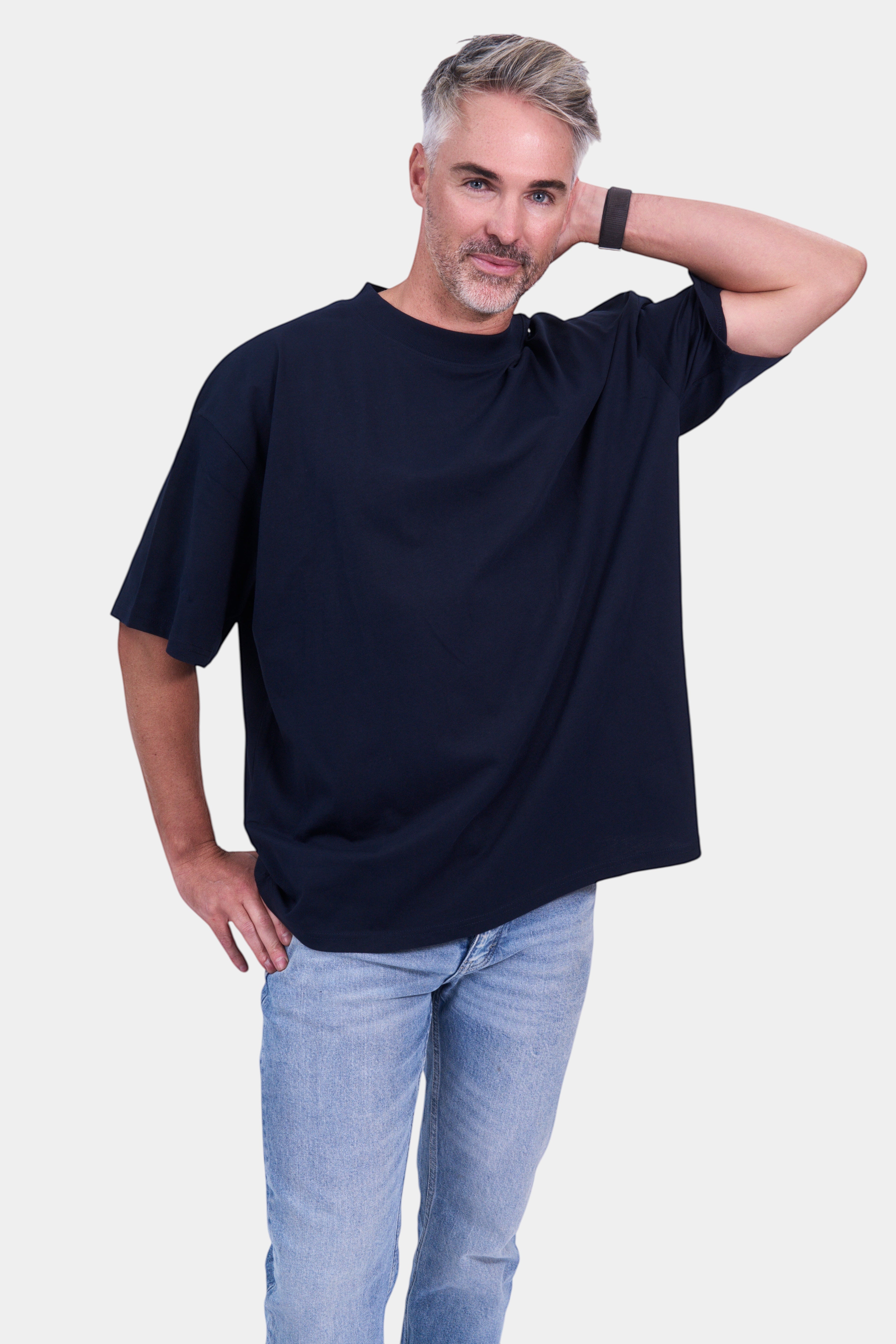 STAPLE Co navy  organic cotton high neck oversized t-shirt on a man wearing light wash jeans.