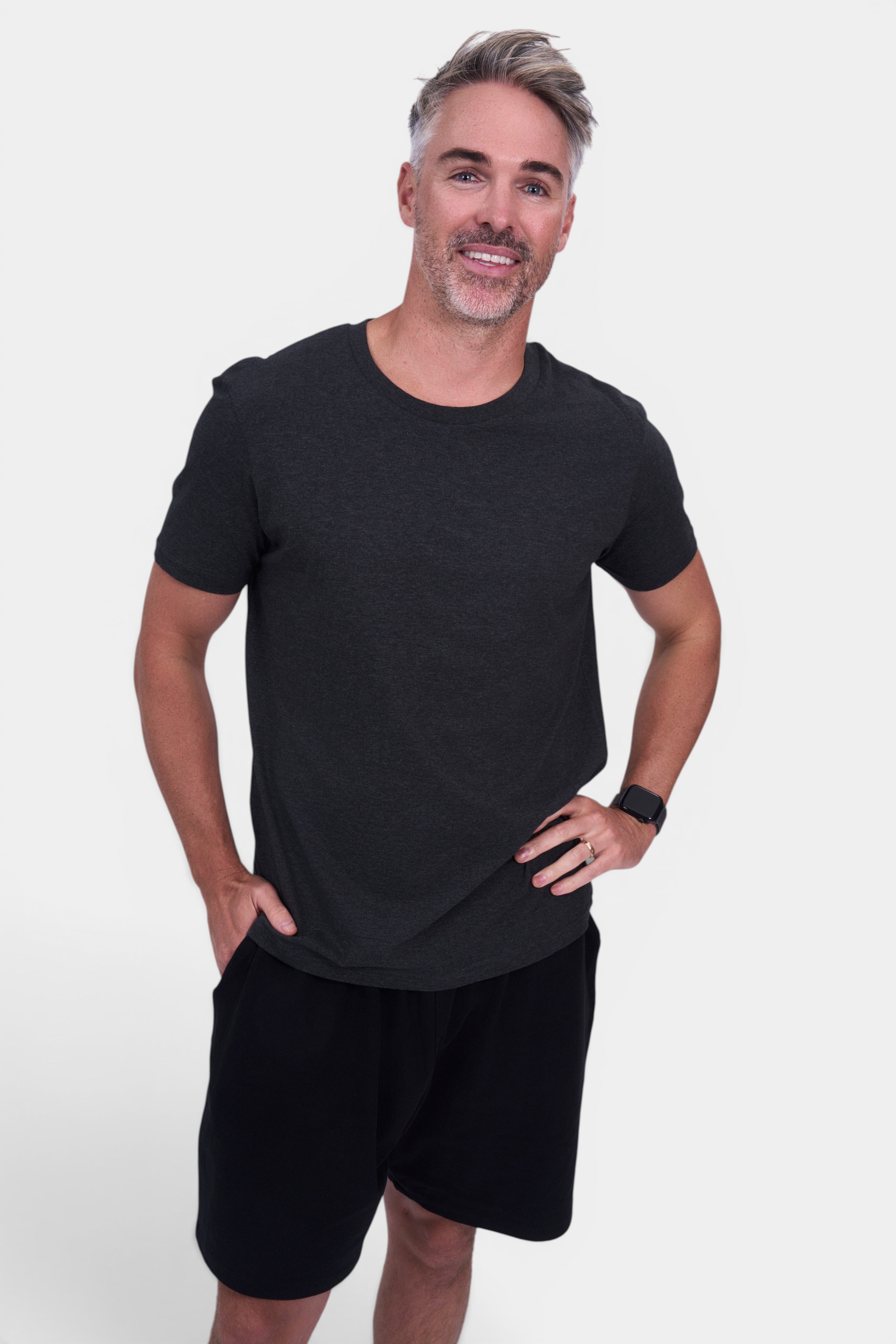 STAPLE Co dark charcoal organic cotton classic fit tee on a man with hands in pockets.