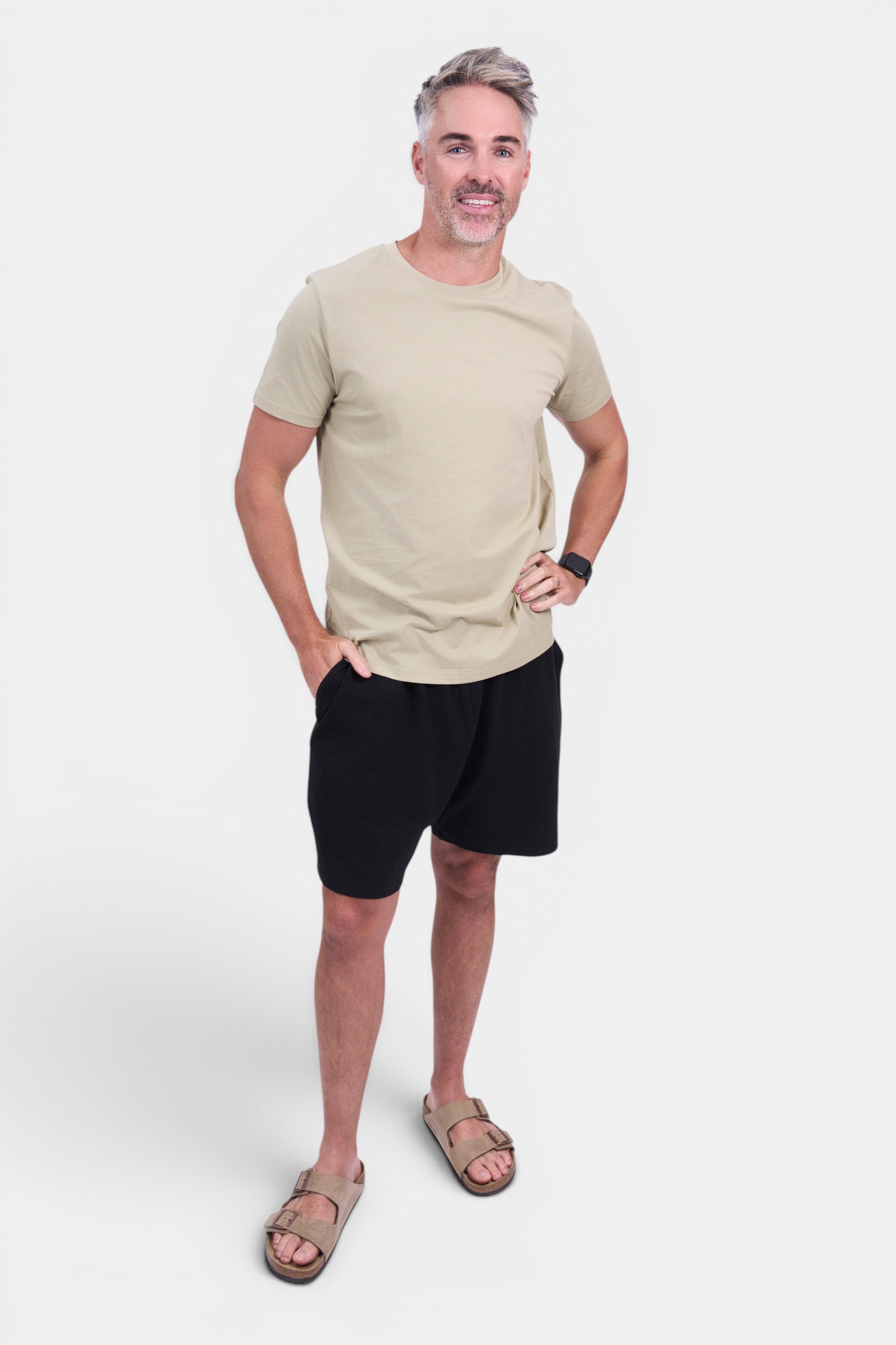 STAPLE Co. men's classic fit organic cotton tee in tan, paired with black shorts and tan sandals.