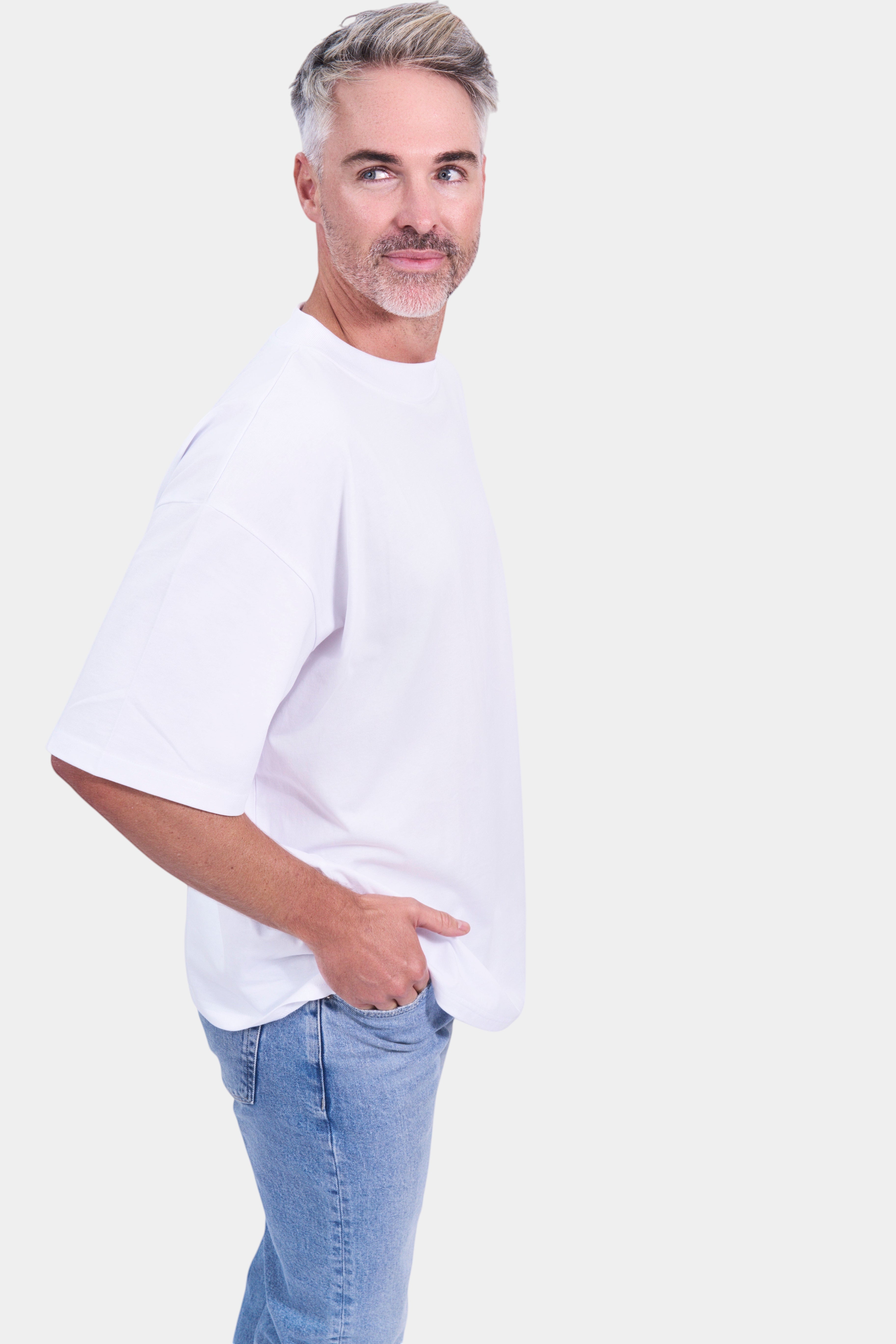 STAPLE Co white organic cotton high neck oversized t-shirt on a man with blue jeans.